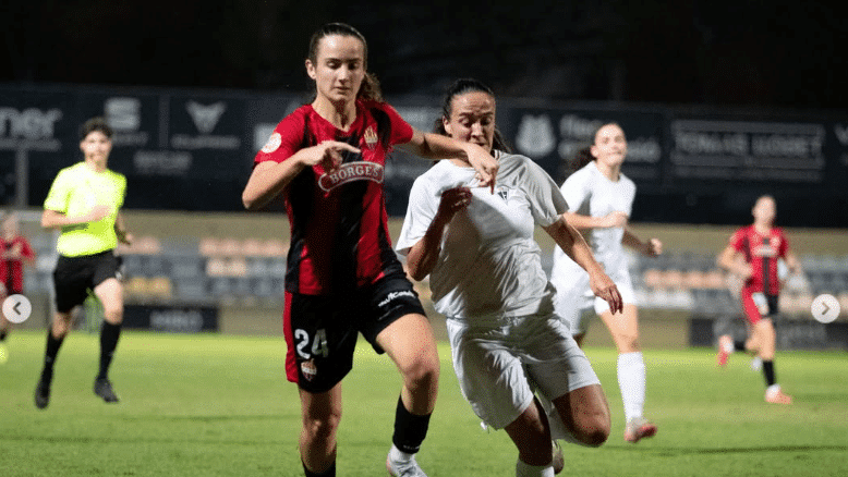 Una jugadora del Reus Femení disputa la pilota amb una rival de l’Igualada