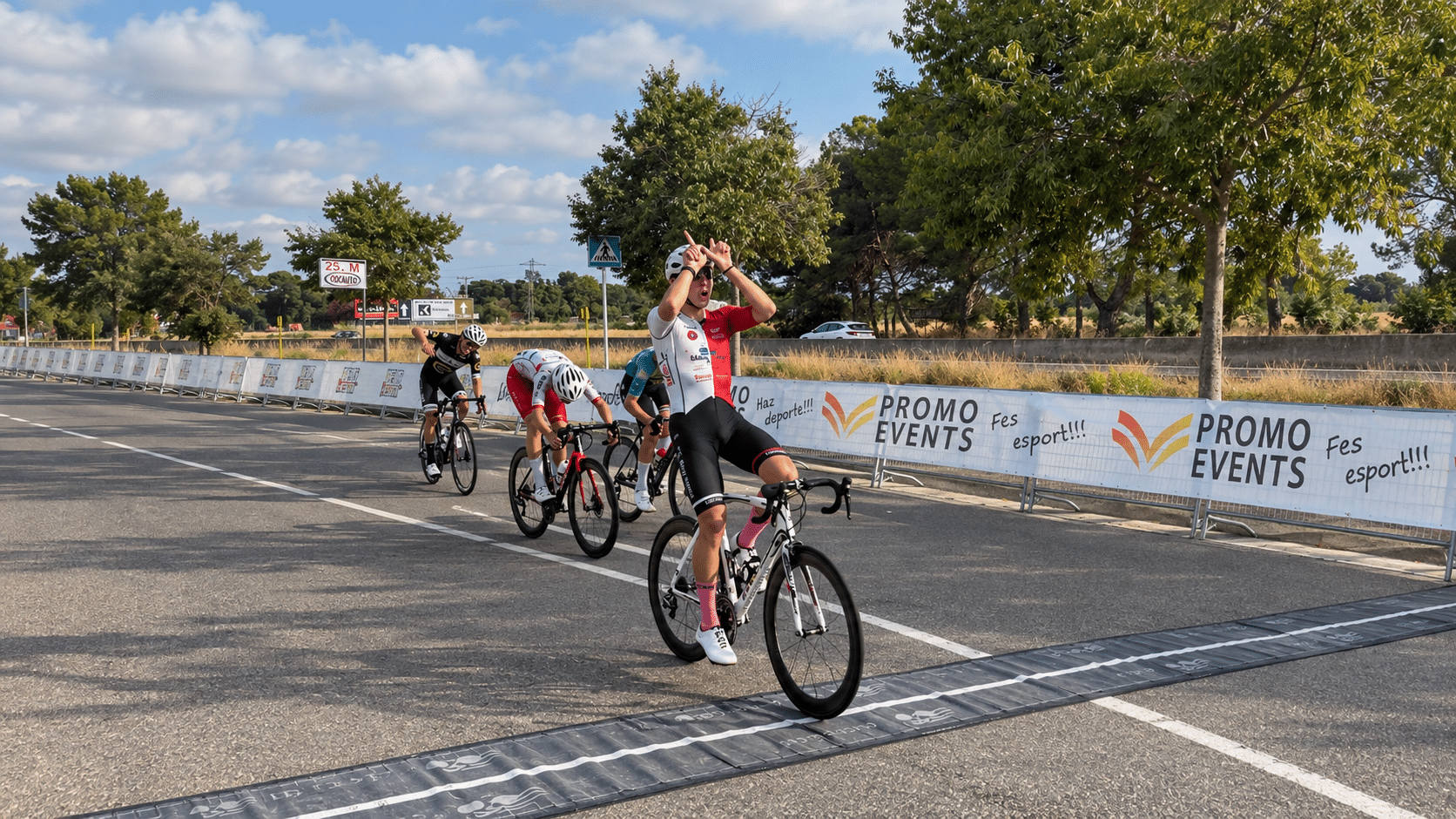 Un ciclista celebra la victòria en creuar la línia de meta