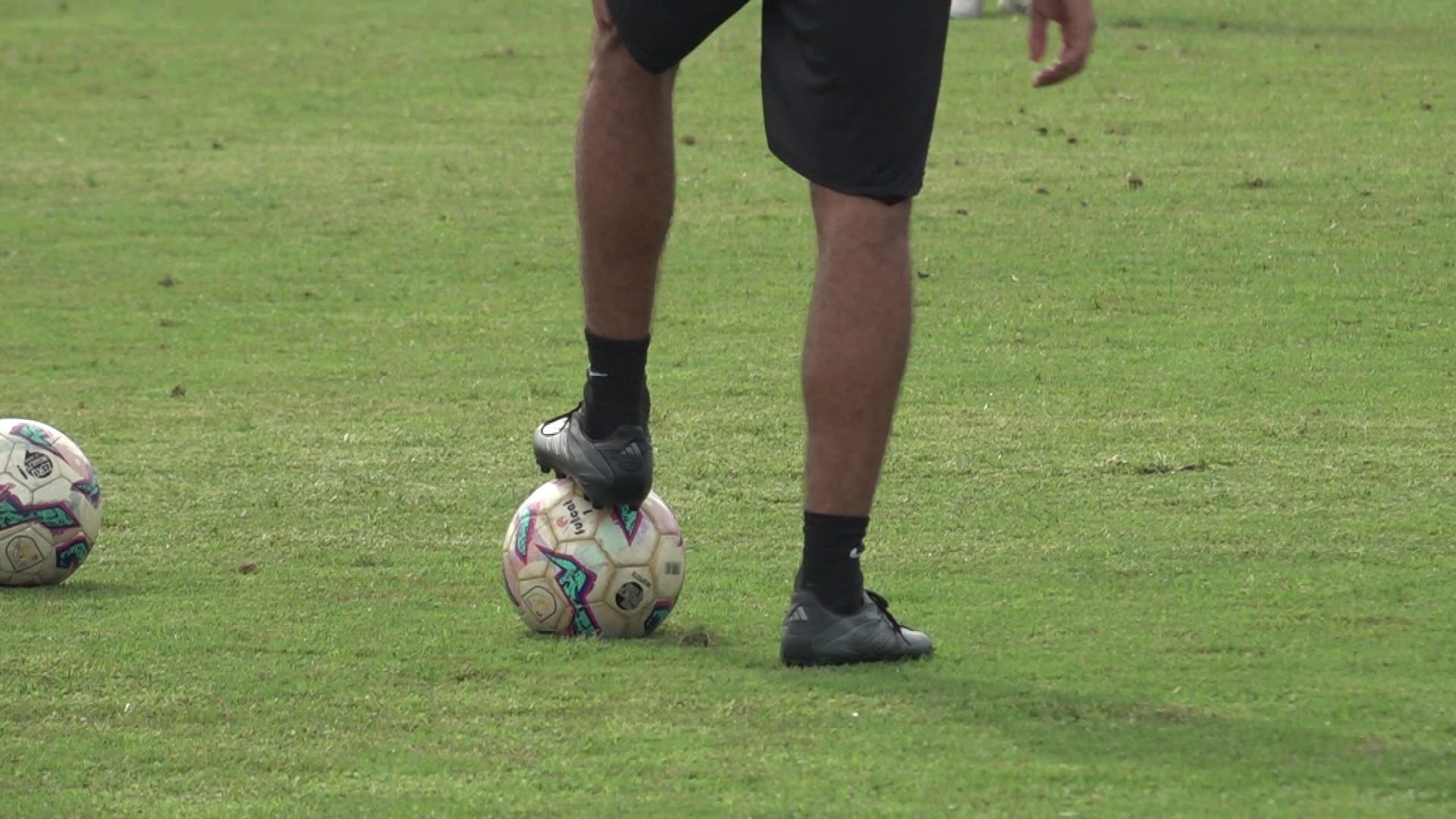 Un jugador trepitja una pilota en un entrenament de futbol abans d’un cap de setmana esportiu