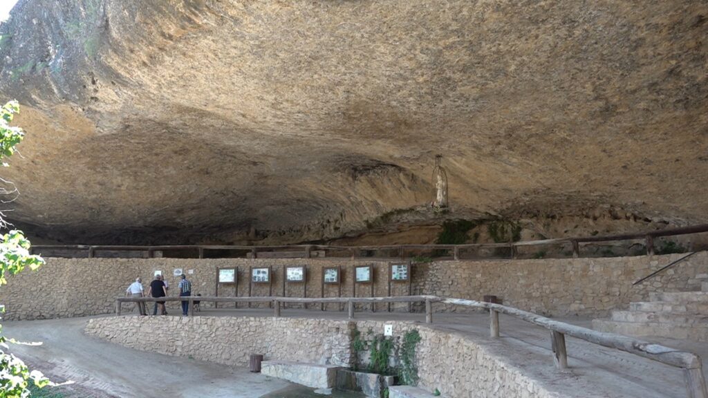 Visitants davant els plafons informatius de la cova de Santa Llúcia de la Bisbal de Montsant