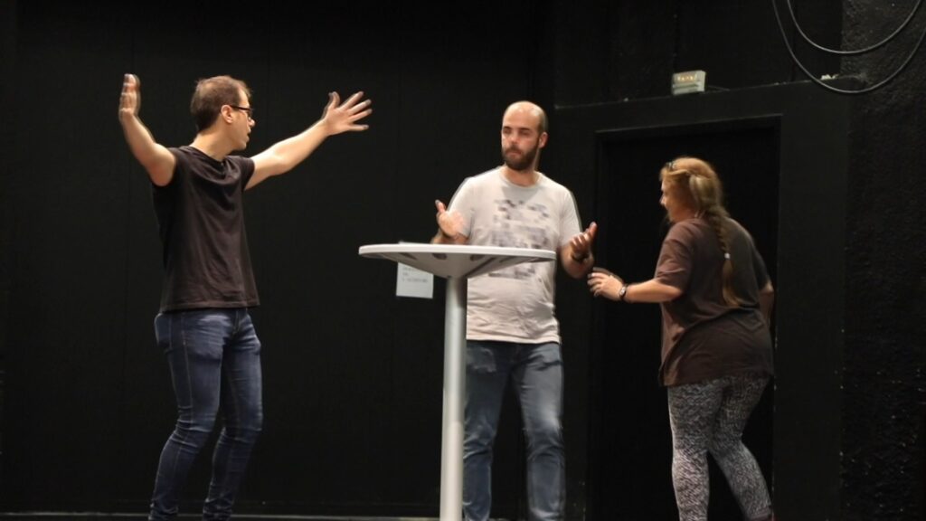 Tres persones treballen tècniques teatrals damunt d’un escenari de l’Escola de Teatre i Cinema de Reus