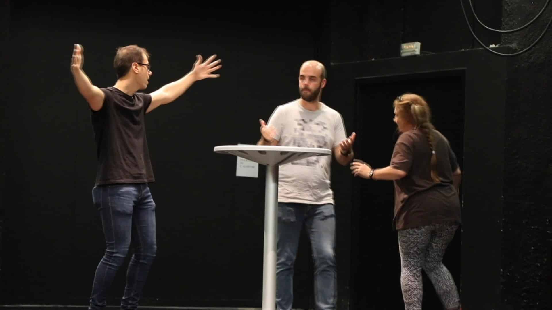 Tres persones treballen tècniques teatrals damunt d’un escenari de l’Escola de Teatre i Cinema de Reus