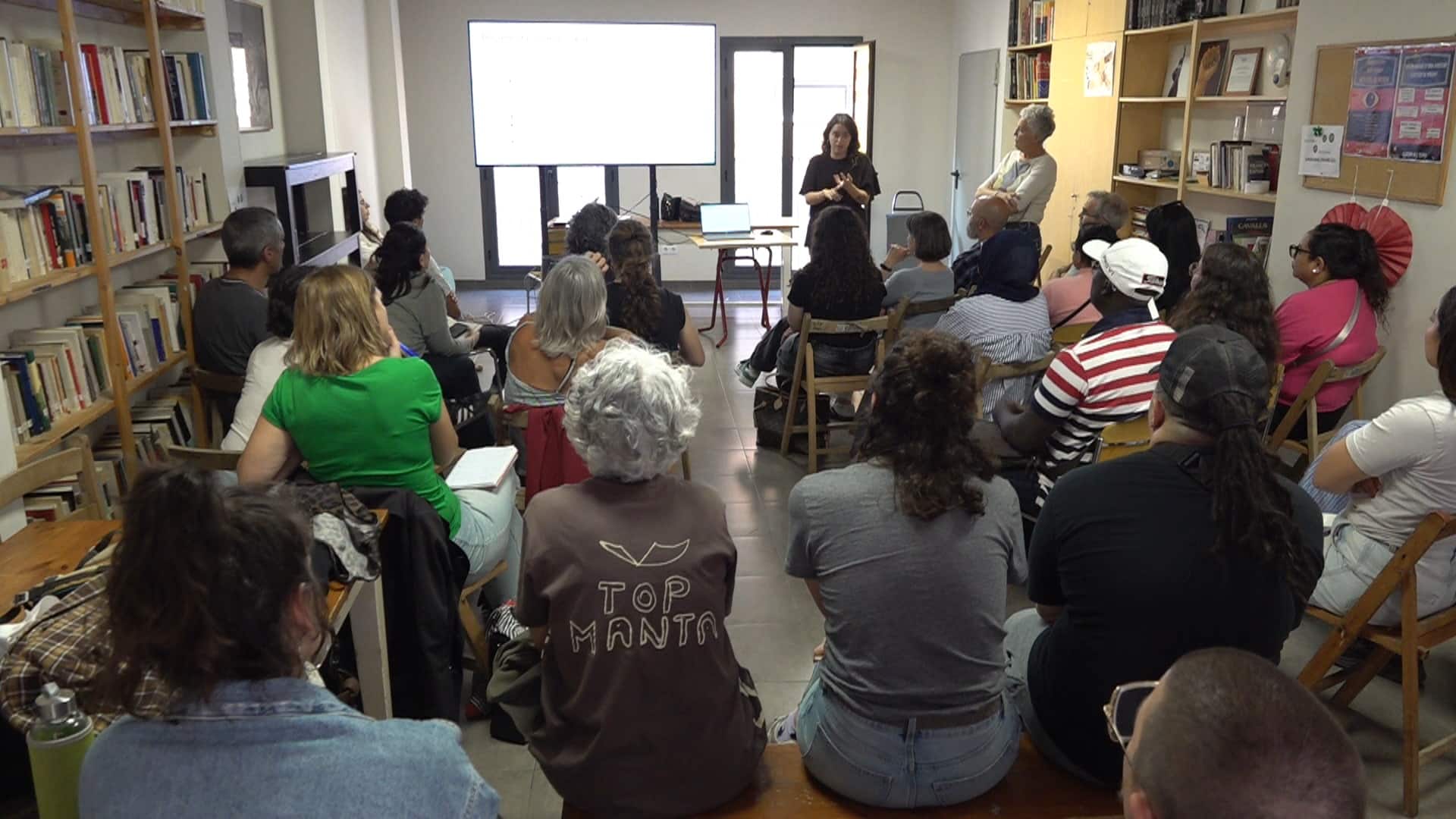 Persones assistents a una sessió formativa en un local amb llibreries