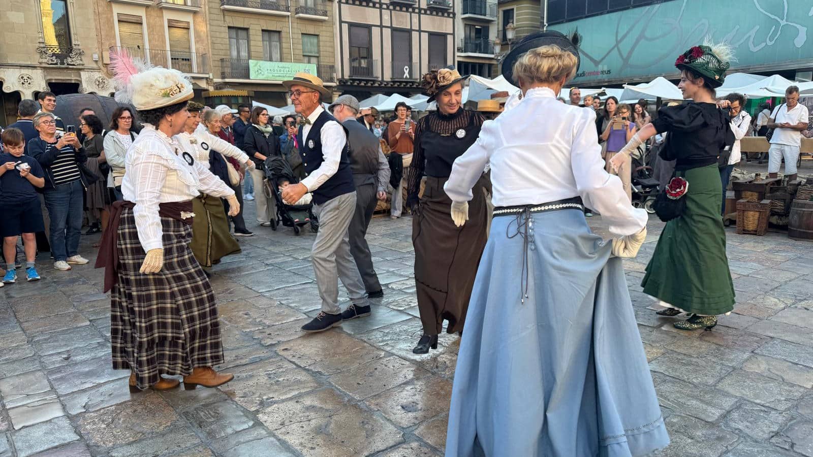 Participants vestits d’època ballen a la plaça del Mercadal durant la Festa Modernista de Reus