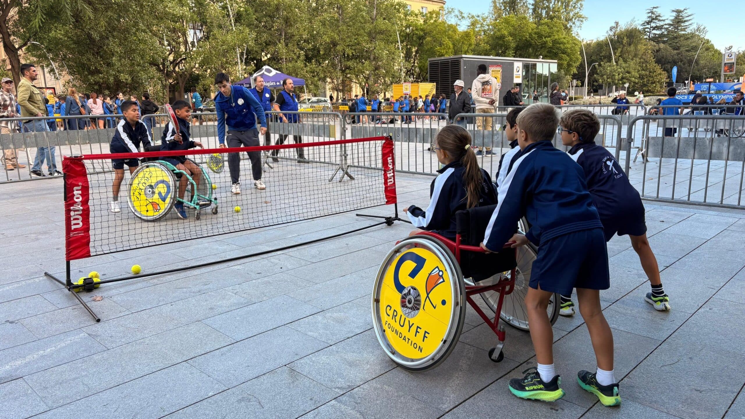 Alumnes juguen a tennis en cadira de rodes a la plaça de la Llibertat durant la Jornada Inclusiva d’Esports per a Tothom