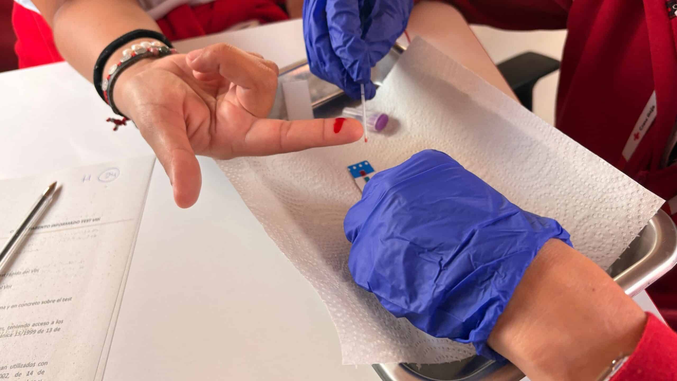 Una voluntària de la Creu Roja fa una prova ràpida del VIH amb una punxada al dit