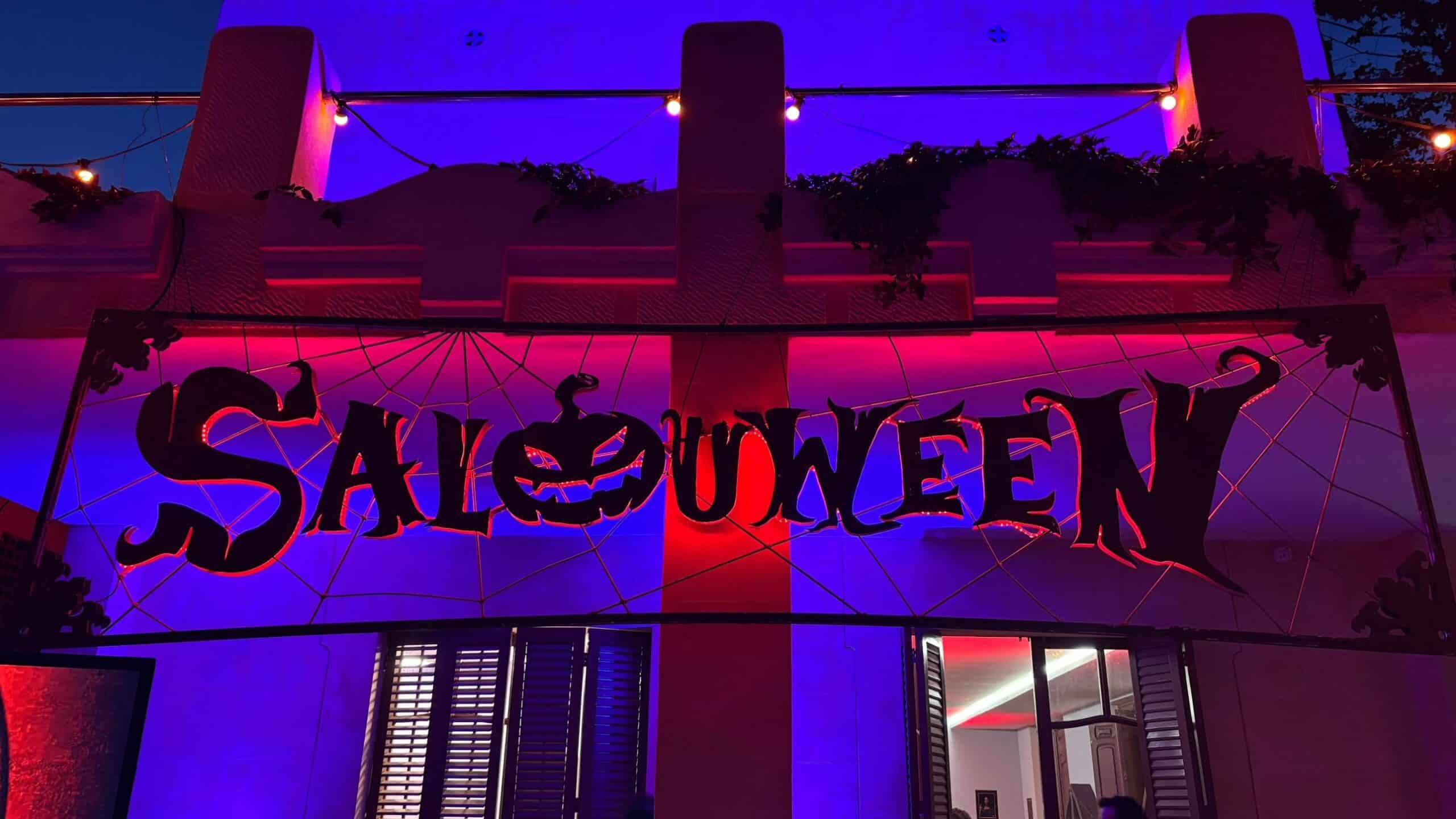 Rètol del Salouween il·luminat amb llums liles i vermelles a la façana d’un edifici de Salou