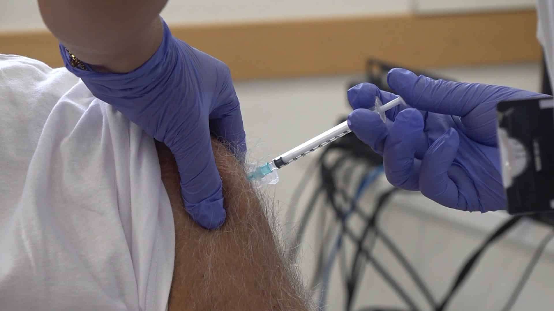 Una professional sanitària administra una vacuna al braç d’un pacient durant la campanya de vacunació contra la grip